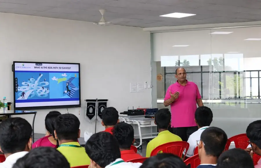 A career counsellor presenting to students on 'What is the real path to success' in a classroom